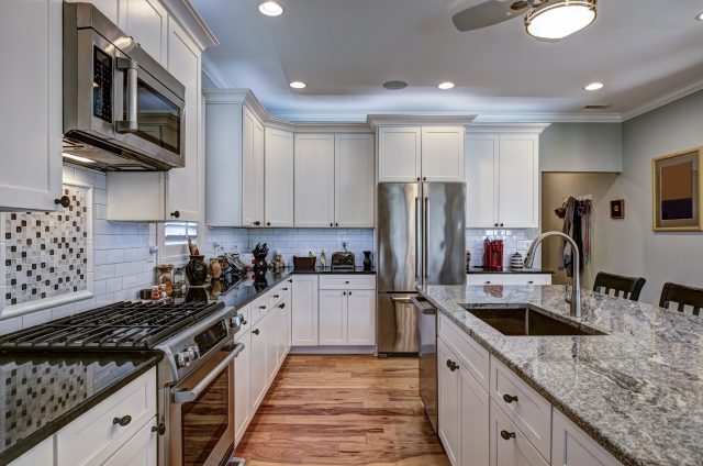 High-end luxury kitchen with granite countertops and white cabinets.